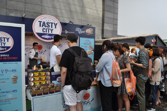 CJ제일제당은 지난 2∼3일 부산 우동 영화의전당에서 열린 '2016 올리브 푸드 페스티벌'에 참가해 브랜드 부스를 운영하며 마케팅 활동을 펼쳤다. 'CJ알래스카연어' 부스에서 사람들이 줄을 지어 제품을 구경하고 있다. <CJ제일제당 제공>